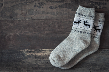 Warm socks with a pattern lie on a wooden backgroundの写真素材