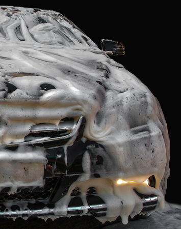 A black passenger car in a lather stands on a sink. Fragmentの写真素材