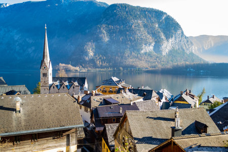 Austrian city Hallstatt on the shore of the Mountain Lake. Surrounded by rocky mountains covered...