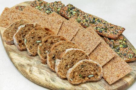 Dry whole grain rye bread in a basket on a wooden stand, close-upの写真素材