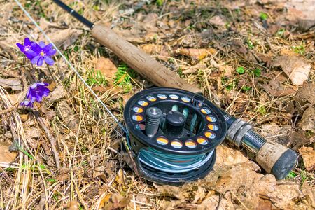A fly fishing rod lies on dry grassの写真素材