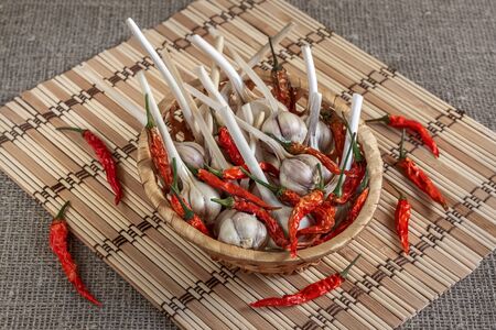 dry pepper and garlic on a straw napkin in a wicker basketの写真素材
