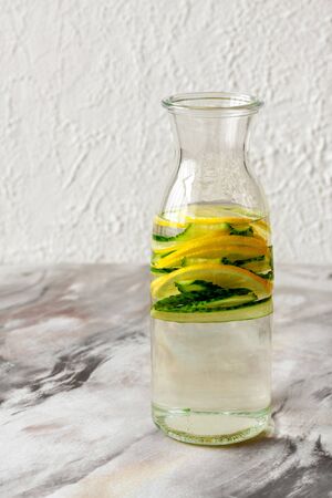 fresh water with lemon and cucumber in a glass bottle close-upの写真素材