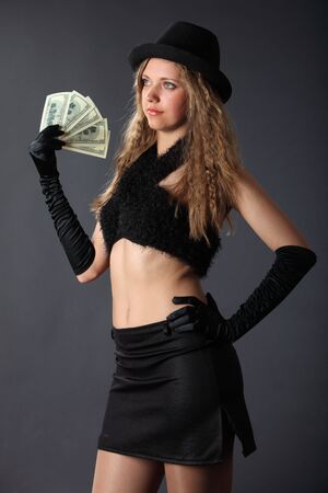 Attractive girl in a hat holding a dollarsの写真素材