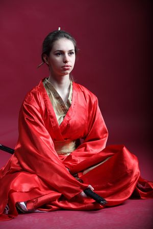 Beautiful brunette girl in a japanese kimono with a katanaの写真素材