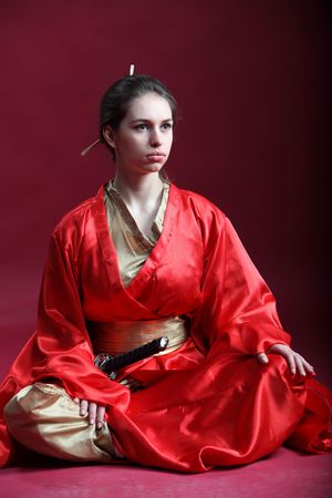 Beautiful brunette girl in a japanese kimono with a katanaの写真素材