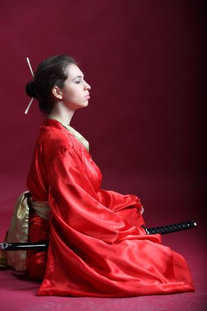 Beautiful brunette girl in a japanese kimono with a katanaの写真素材