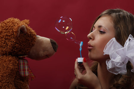 Young pretty girl play with a soap bubbles