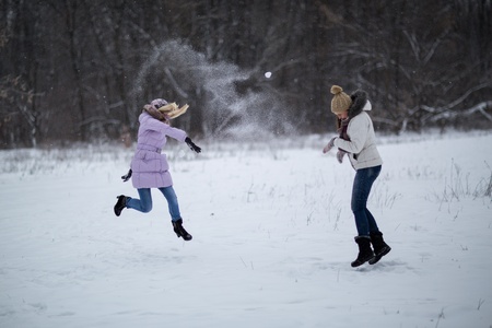 Two girls playing in the snowの写真素材