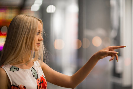 Beautiful girl looking in the shopwindow on the night city street