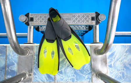 Swimming fins are on the edge of the pool. Children's pool for water sports.の写真素材