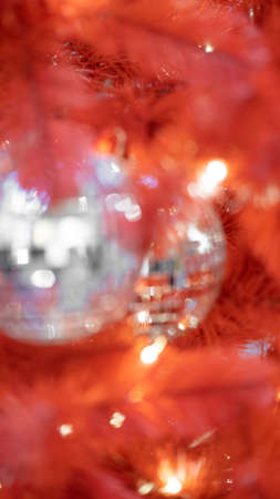Christmas toy Disco ball on red christmas tree. Close-up. New year decorationの写真素材
