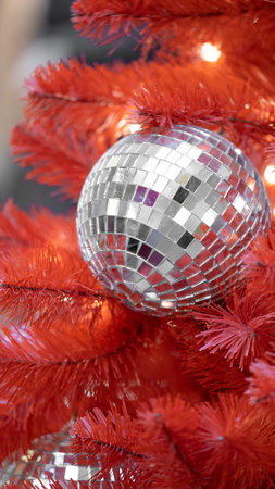Christmas toy Disco ball on red christmas tree. Close-up. New year decorationの写真素材