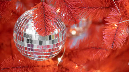 Christmas toy Disco ball on red christmas tree. Close-up. New year decorationの写真素材