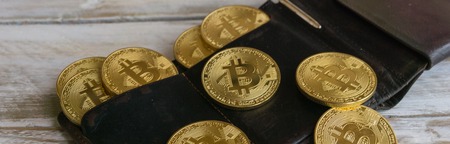 Golden Bitcoins with leather wallet on a wooden tableの写真素材