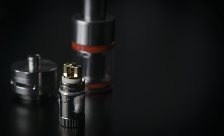 Repair,maintenance vaper device mod. Parts of modern vaporizer e-cig device,spare parts.Micro coil clearomizer.Modern ecig vape module closeup. Side view.の写真素材