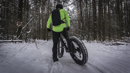 Fat bike also called fat bike or fat-tire bike - Cycling on large wheels in the winter forest.の写真素材