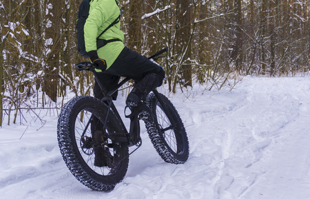 Fat bike also called fat bike or fat-tire bike - Cycling on large wheels in the winter forest.の写真素材