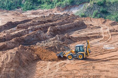 Wheel loader excavator machine working in construction site. wheel loader at sandpit during earthmoving works.の写真素材