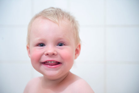 Happy funny little boy smiling in the bathroom. happy funny baby laughing and bathed in the bathの写真素材