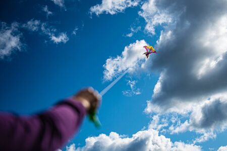 womans handing the rope while playing kite in the sky, enjoy lifestyle in freedomの写真素材