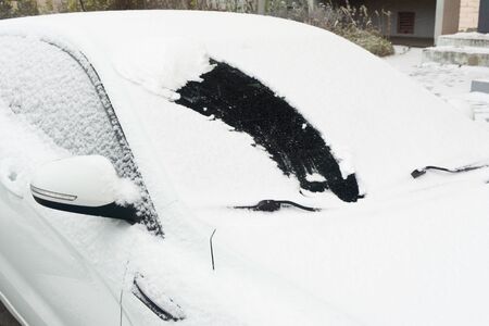 Snow-covered car windshield. parked car covered with snow during snowing in winter timeの写真素材
