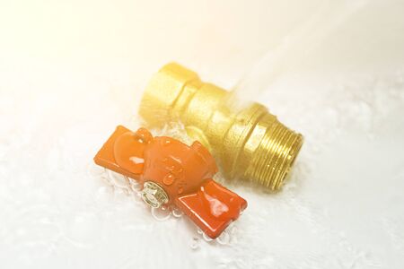 sanitary ball valve under the water flow. close up. Plumbing equipment.の写真素材