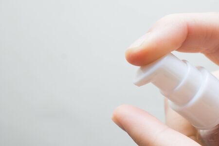 woman hands applying moisturizing cream to her finger skin from a tube. beautiful girl dropping collagen moisturizer serum into her hand at homeの写真素材