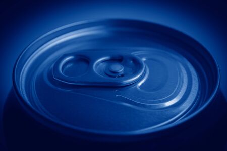 Close-up of the top of aluminum can for soft drinks or beer with still closed cap toned in trendy color Classic Blue. side shot.の写真素材