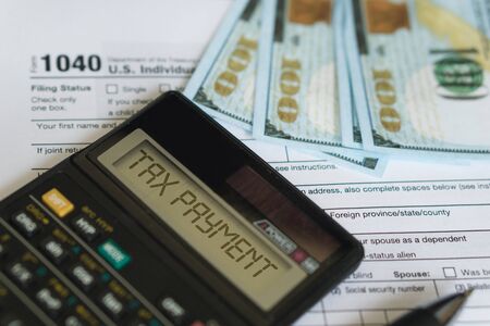 Business and tax concept. Tax form 1040, pen and calculator on the desk. Taxation concept.の写真素材