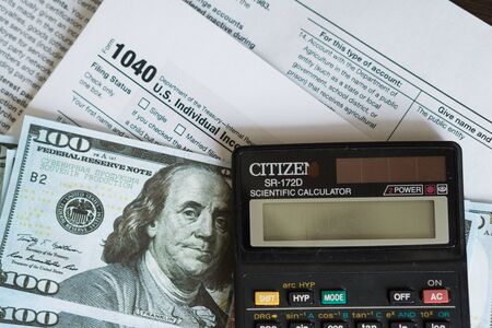 Business and tax concept. Tax form 1040, pen and calculator on the desk. Taxation concept.の写真素材