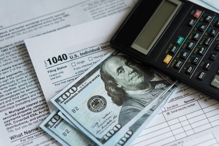 Business and tax concept. Tax form 1040, pen and calculator on the desk. Taxation concept.の写真素材