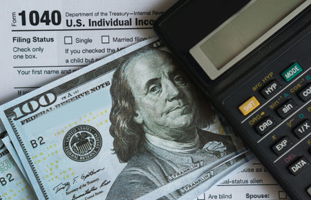 Business and tax concept. Tax form 1040, pen and calculator on the desk. Taxation concept.