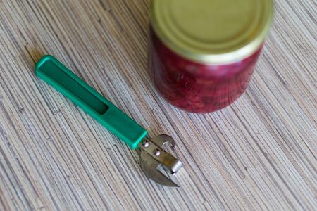 can of canned borscht with a hand-held can opener.の写真素材