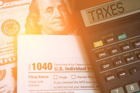 Business and tax concept. Tax form 1040, pen and calculator on the desk. Taxation concept.の写真素材