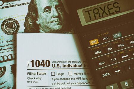 Business and tax concept. Tax form 1040, pen and calculator on the desk. Taxation concept.の写真素材