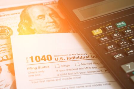 Business and tax concept. Tax form 1040, pen and calculator on the desk. Taxation concept.の写真素材