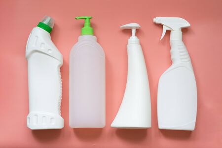 4 types of plastic bottles for household chemicals. Packaging for liquids. Empty, clean white plastic containers. Top view on a pink pastel backgroundの写真素材