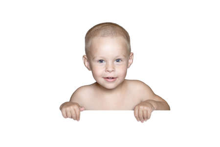 little child behind white board. Cute boy holding white board and looking in camera, isolated on whiteの写真素材