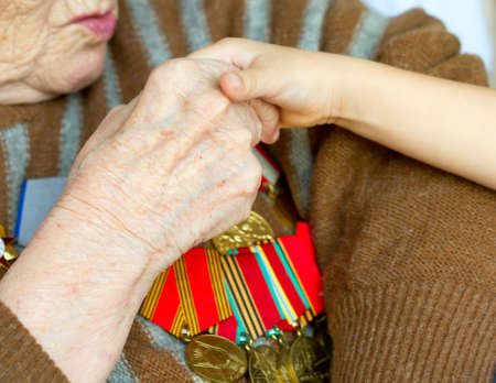 Grandmother kisses the hand of his grandson. Veteran of World War 2 の写真素材