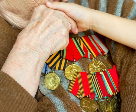 Grandmother kisses the hand of his grandson. Veteran of World War 2 の写真素材