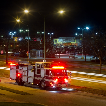 Firetruck is on the side of the road at night in the city のeditorial素材