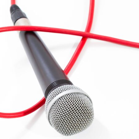 Microphone with red cable on white backgroundの写真素材