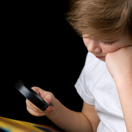 Boy reading a book through magnifying glass