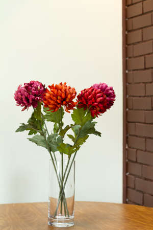 Vase with  flowers on the table and brick wall backgoundの写真素材