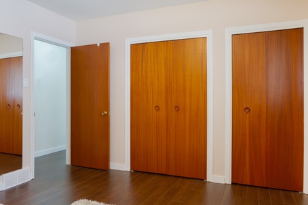 Wooden doors of the closets with mirror in the bedroomの写真素材