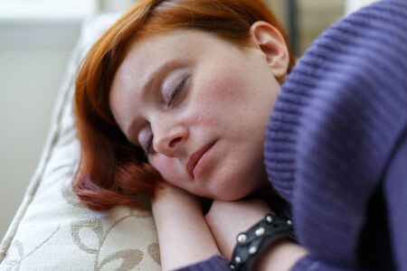 Young woman sleeping on a sofa の写真素材