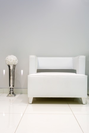 Interior with white armchair and vase near white wall.の写真素材