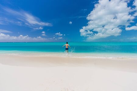 Tropical beach background with white sand beach and swimming man in Cayo Largo island. Cubaの写真素材