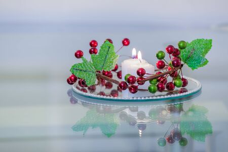 Interior with candles on a mirror plate with decorative flowersの写真素材